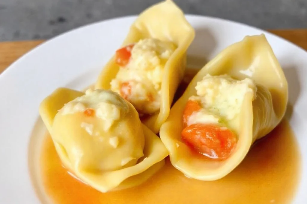 A close-up of three cheese tortellini showing the creamy ricotta, mozzarella, and Parmesan filling.