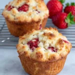 Freshly baked Almond Flour Strawberry Muffins made with almond flour, fresh strawberries, and Greek yogurt, displayed on a wire cooling rack in a bright home kitchen. Moist gluten-free muffins with golden tops and visible strawberry pieces, photographed in natural window light with a warm homemade feel.