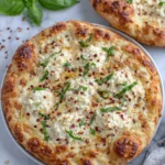 Freshly baked Hot Honey Ricotta Pizza topped with creamy ricotta cheese, melted mozzarella, hot honey drizzle, fresh basil, and red pepper flakes on a golden crispy crust, photographed in natural light on a wooden board in a home kitchen.