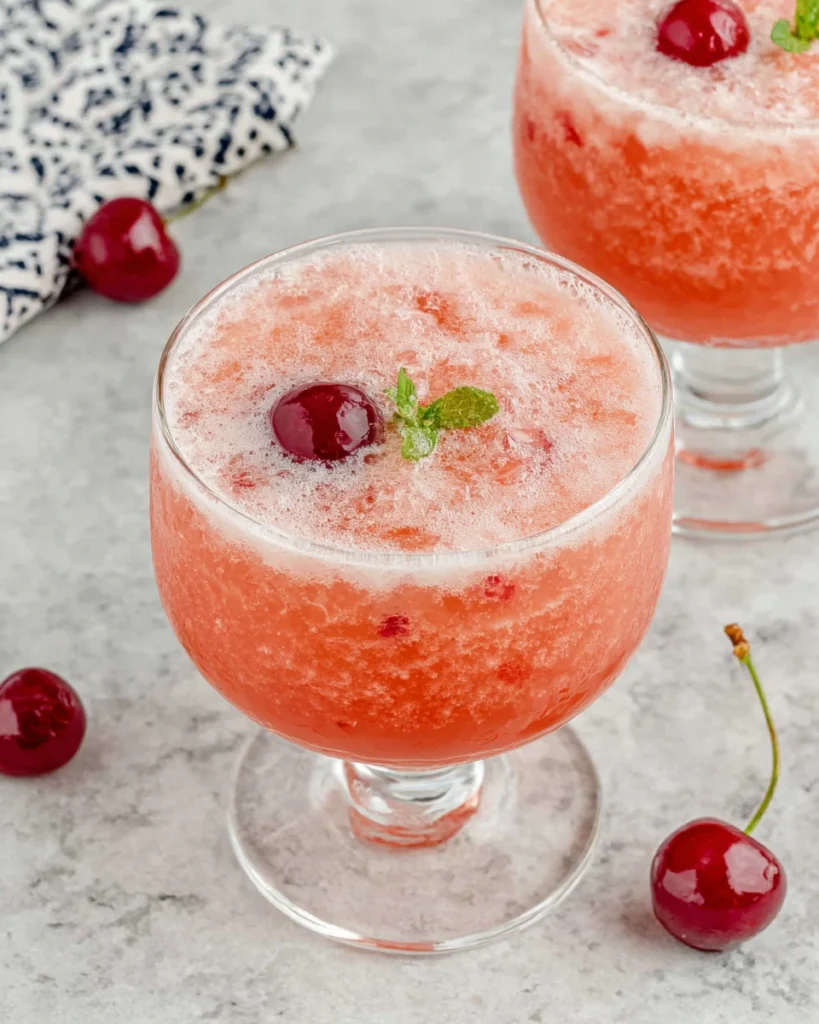 Pink Lady Mocktail served in a chilled coupe glass with a fluffy foam topping and cherry garnish. This refreshing non-alcoholic drink is made with apple juice, fresh lemon juice, grenadine, and club soda, creating a beautiful pink color and elegant presentation perfect for parties, brunches, and special occasions.