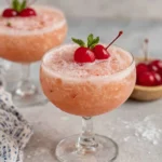 Pink Lady Mocktail served in a chilled coupe glass with a fluffy foam topping and cherry garnish. This refreshing non-alcoholic drink is made with apple juice, fresh lemon juice, grenadine, and club soda, creating a beautiful pink color and elegant presentation perfect for parties, brunches, and special occasions.