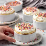 Vanilla Dot Cakes topped with creamy vanilla cream cheese frosting and colorful nonpareils, featuring a soft, moist vanilla cake with visible vanilla bean specks, photographed in natural light on a white marble countertop.