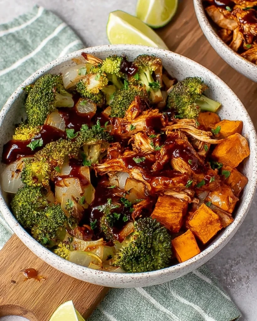 Make these Roasted BBQ Chicken and Sweet Potato Bowls for an easy one-pan dinner packed with juicy BBQ chicken, roasted sweet potatoes, broccoli, and onions. This healthy recipe is perfect for busy weeknights, meal prep, and family dinners. Ready in under an hour, it's loaded with smoky, sweet, and savory flavors everyone will love.