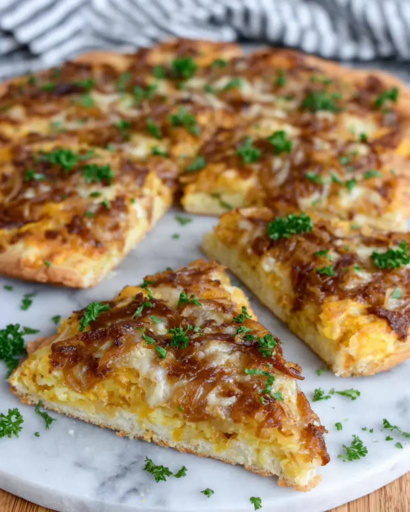 5 Ingredient Pumpkin and Gouda Pizza topped with creamy pumpkin puree, melted Gouda cheese, caramelized onions, garlic, and fresh parsley on a crisp homemade pizza crust.
