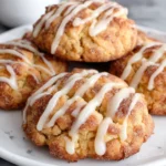Soft and chewy apple cider cookies coated in cinnamon sugar and drizzled with apple cider glaze on a white marble counter.