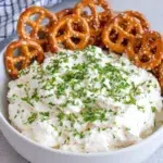 Creamy Margarita Dip with Salted Pretzels served in a bowl, topped with fresh lime zest and surrounded by crunchy salted pretzels on a white marble kitchen counter.