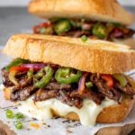 Make this Korean Steak Sandwich with juicy ribeye, gochujang marinade, melted cheddar, jalapeños, peppers, and creamy garlic mayo. A flavorful lunch everyone will love.